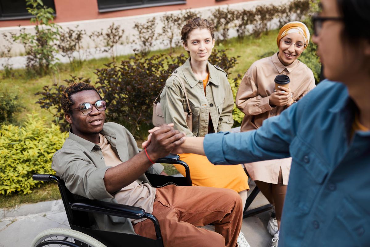 making-handshake-with-man-in-wheelchair