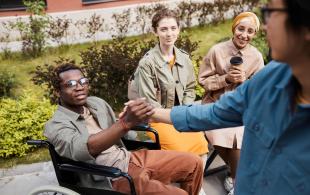 making-handshake-with-man-in-wheelchair